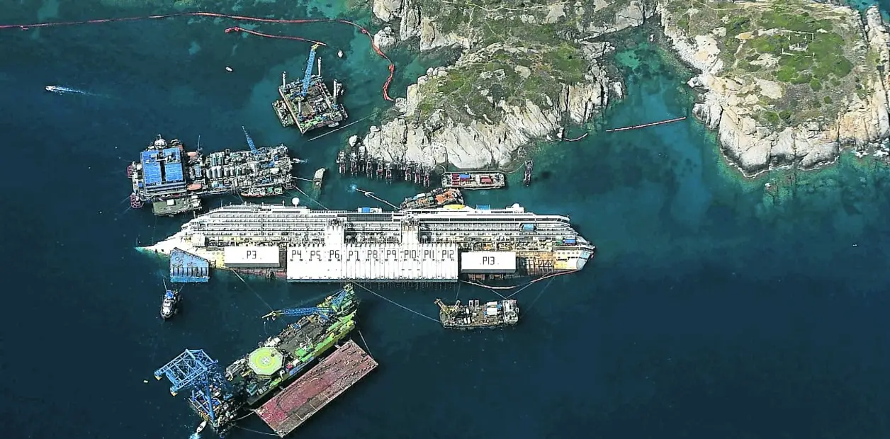 Vista lateral del Costa Concordia escorado frente a la isla de Giglio