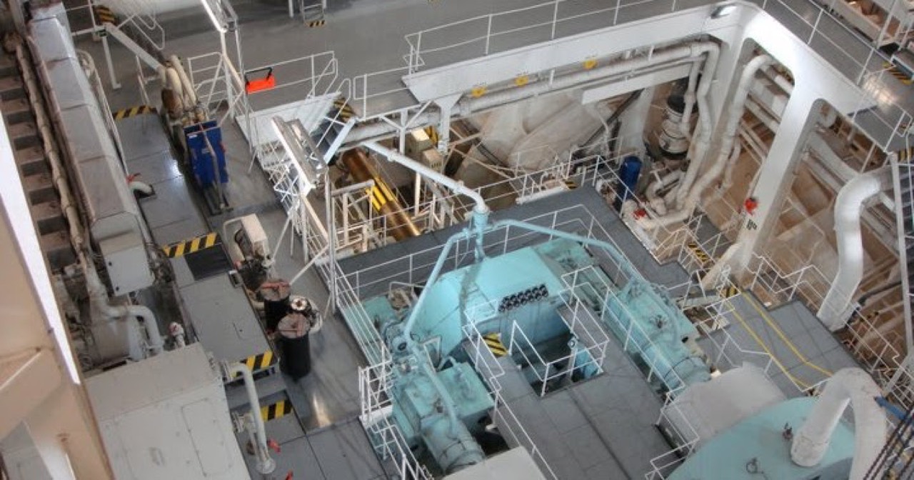 Equipo técnico inspeccionando maquinaria principal en sala de máquinas